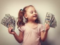Happy kid girl holding cash dollars and looking with smile. Vint Royalty Free Stock Photo