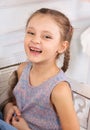 Happy kid girl laughing in colorful blouse. Closeup studio portrait