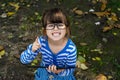 Happy kid girl looking in camera with happy and peaceful expression in glasses, holding in his hands pc tablet.