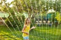 Happy kid girl playing with garden sprinkler run and jump, summer Royalty Free Stock Photo