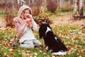 Happy kid girl playing with her cavalier king charles spaniel dog in autumn Royalty Free Stock Photo