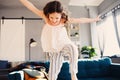 Happy kid girl playing at home in weekend morning and jumping on couch Royalty Free Stock Photo