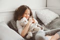 Happy kid girl playing with teddy bears in her room, sitting on bed Royalty Free Stock Photo