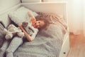 Happy kid girl playing with teddy bears in her room, sitting on bed Royalty Free Stock Photo