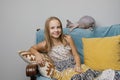 Happy kid girl relaxing on the sofa at home. Smiling girl with cat pet enjoying day off sitting on the couch Royalty Free Stock Photo