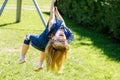 Happy kid girl rids on zip line swing outdoor game play equipment on playground. Child having fun outdoors. Preschool