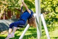 Happy kid girl rids on zip line swing outdoor game play equipment on playground. Child having fun outdoors. Preschool