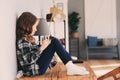 Happy kid girl sitting on table at home and wring. Royalty Free Stock Photo