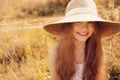 Happy kid girl in straw having fun outdoor on summer sunny field Royalty Free Stock Photo