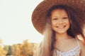 Happy kid girl in straw having fun on summer field Royalty Free Stock Photo