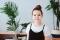 happy kid girl taking care of houseplants at home, dressed in stylish black and white outfit Royalty Free Stock Photo