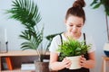 Happy kid girl taking care of houseplants at home, dressed in stylish black and white outfit