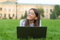Happy kid in glasses learn online in virtual school using laptop computer technology on green grass outdoors, elearning Royalty Free Stock Photo