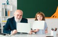 Happy kid with grandfather hold paper board. Senior Teacher help to learn. Education, teachering, elementary school. Royalty Free Stock Photo