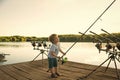 Happy kid having fun. Angling child with fishing rod on wooden pier Royalty Free Stock Photo