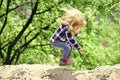 Happy kid having fun. Child bounce on sand in spring or summer park