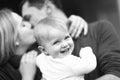 Happy kid having fun. Boy smiles while parents kiss