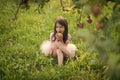 Happy kid having fun. Cute baby girl eating apple under huge tree Royalty Free Stock Photo