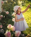 Happy kid having fun. Girl in hat pointing finger in summer garden