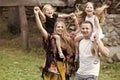 Happy kid having fun. Girls sit on mothers and fathers shoulders on natural landscape. Happy family.