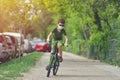 Happy kid having fun near home with a bicycle on beautiful spring day wearing protection mask for coronavirus Covid-19 pandemic Royalty Free Stock Photo