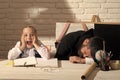 Happy kid having fun. Schoolgirl with shocked face and her sleeping tutor Royalty Free Stock Photo