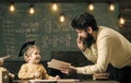 Happy kid having fun. Wunderkind and genius concept. Father, teacher reading book, teaching kid, son, chalkboard on