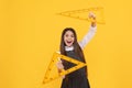 happy kid hold math triangle ruler in school on yellow background, education Royalty Free Stock Photo