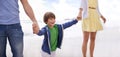 Happy, kid and holding hands with parents on the beach for walk in summer, holiday or vacation with happiness. Excited Royalty Free Stock Photo