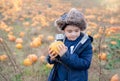 Happy kid holding pumpkin, Cute boy having fun playing outdoor in Autumn field. Smiling Child playing outside for trick or teat on Royalty Free Stock Photo