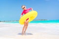 Happy kid with inflatable rubber circle having fun on the white beach