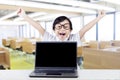 Happy kid with laptop raise hands in class Royalty Free Stock Photo