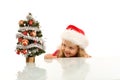 Happy kid lurking around a small christmas tree Royalty Free Stock Photo