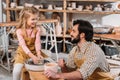 happy kid making ceramic pot on pottery wheel with teacher Royalty Free Stock Photo