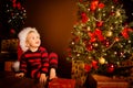 Happy Kid near Christmas Tree, Happy Baby Boy in Night Xmas Room, Child in Red Santa Hat, Present gift box