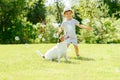 Happy kid and pet dog playing with soap bubbles at backyard lawn Royalty Free Stock Photo