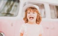 Happy kid in pink clothes car. Child hippie. Happy toddler child having fun for travel in retro minivan. Royalty Free Stock Photo