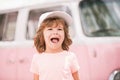 Happy kid in pink clothes car. Child hippie. Happy toddler child having fun for travel in retro minivan. Royalty Free Stock Photo