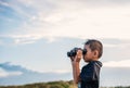 Happy kid playing binoculars in the meadows. Royalty Free Stock Photo