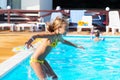 Happy kid playing in blue water of swimming pool. Little girl le Royalty Free Stock Photo