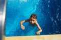 Happy kid playing in blue water of swimming pool on a tropical r Royalty Free Stock Photo