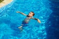 Happy kid playing in blue water of swimming pool on a tropical r Royalty Free Stock Photo