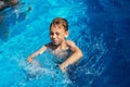 Happy kid playing in blue water of swimming pool on a tropical r Royalty Free Stock Photo