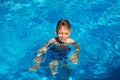 Happy kid playing in blue water of swimming pool on a tropical r Royalty Free Stock Photo