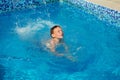 Happy kid playing in blue water of swimming pool on a tropical r Royalty Free Stock Photo