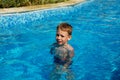 Happy kid playing in blue water of swimming pool on a tropical r Royalty Free Stock Photo