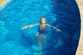 Happy kid playing in blue water of swimming pool on a tropical r Royalty Free Stock Photo