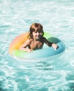 Happy kid playing with colorful swim ring in swimming pool. Child water toys. Children play in tropical resort. Family Royalty Free Stock Photo