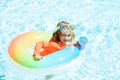 Happy kid playing with colorful swim ring in swimming pool on summer day. Child water toys. Children play in tropical Royalty Free Stock Photo