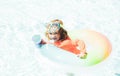 Happy kid playing with colorful swim ring in swimming pool on summer day. Child water toys. Children play in tropical Royalty Free Stock Photo